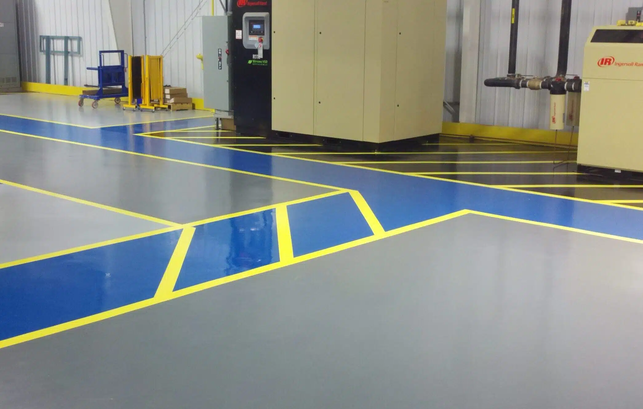 High-performance warehouse epoxy flooring with yellow safety line striping by Resin Masters